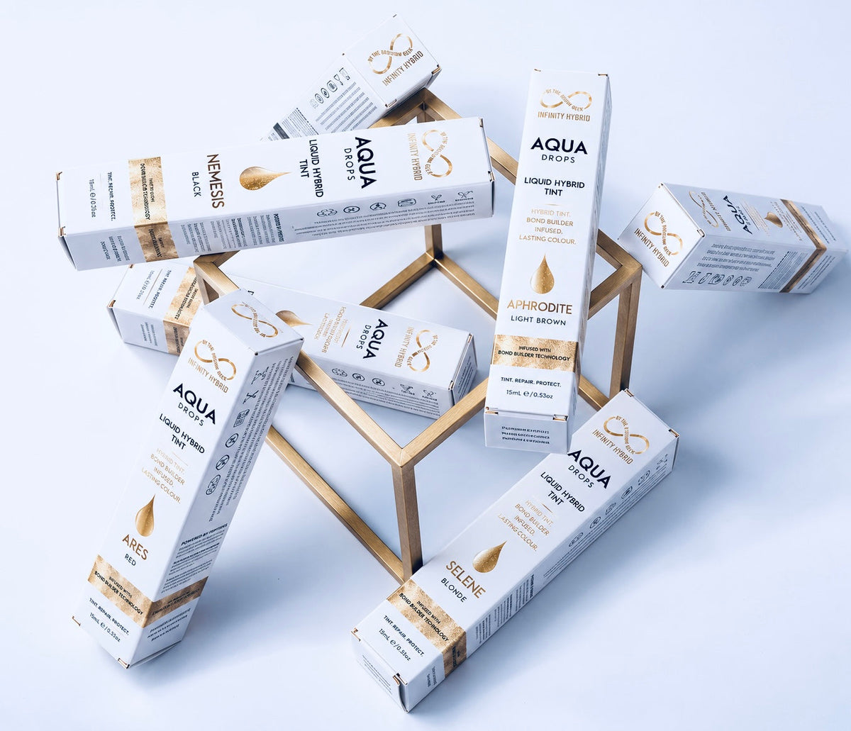 Aqua Drops® liquid hybrid brow dye 15ml boxes in the new design on a gold stand, Infinity by The Brow Geek